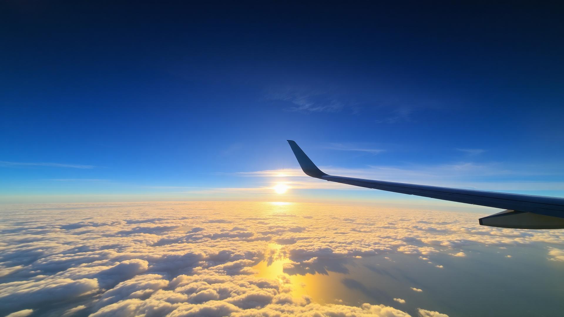 Flygplansvinge över molnen i soluppgången